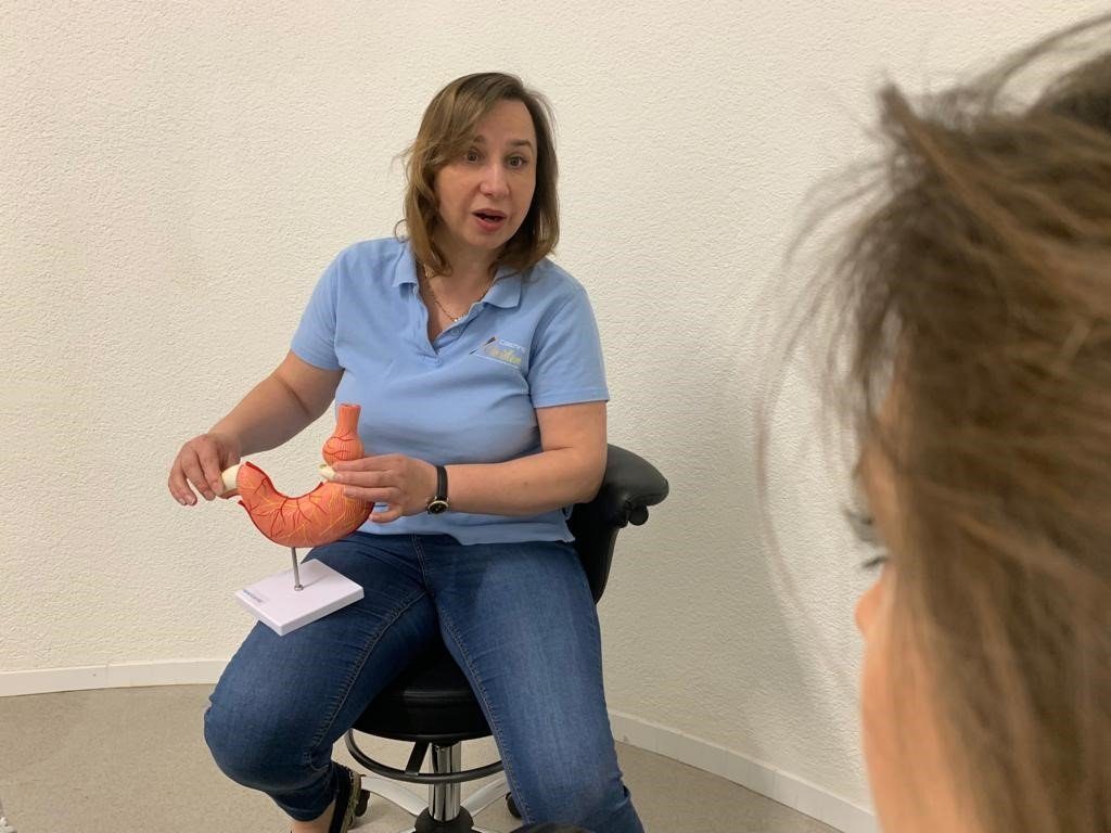 Alena Telezin von der Hypnose Akademie zeigt ein Magenband