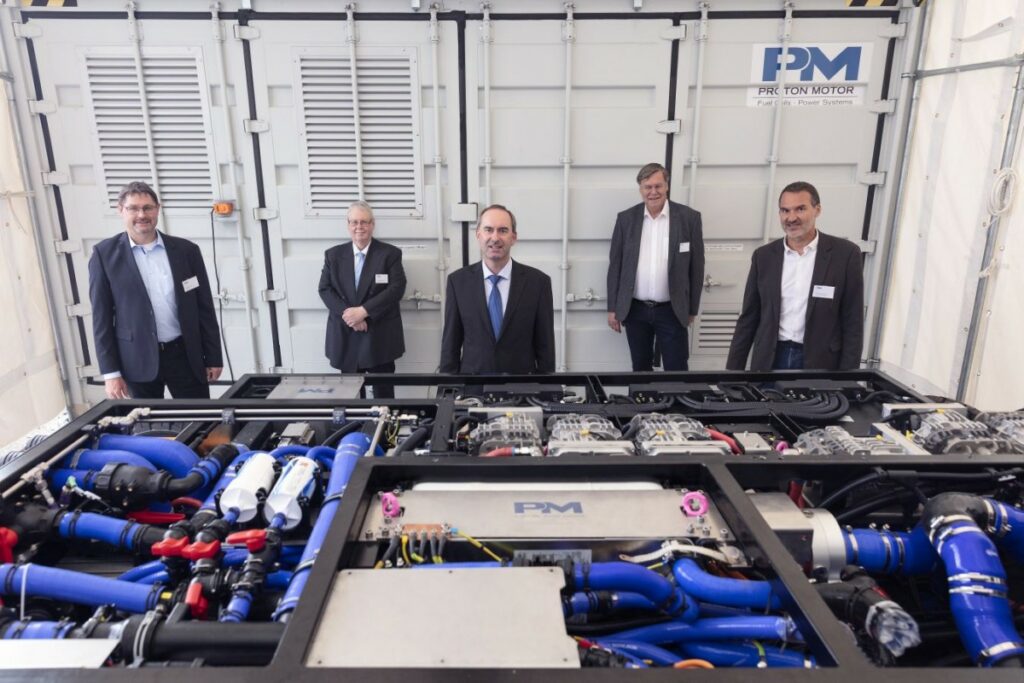 Die geschäftsführenden Proton Motor-Manager mit Minister Aiwanger (M.) vor neuem Multistack-System  (© Proton Motor)