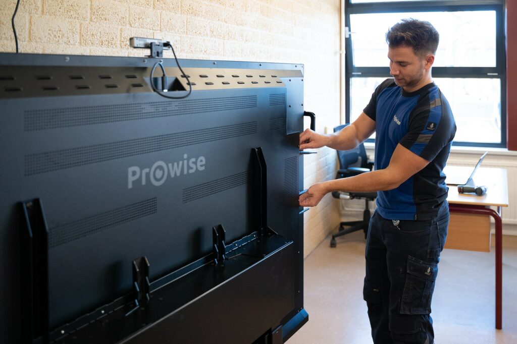 Prowise-Mitarbeiter installiert einen Touchscreen in einem Klassenraum