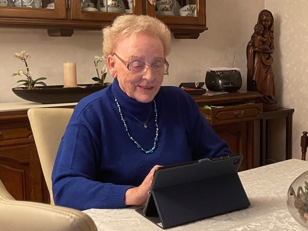 Seniorin nimmt an Kulturprogramm über Zoom mit dem Lylu Tablet teil.