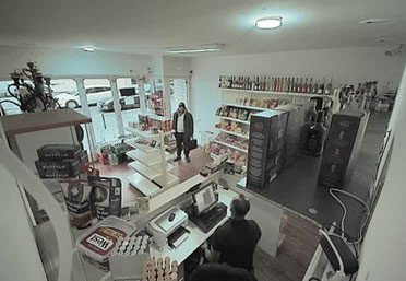 Der bedrohte Kiosk-Mitarbeiter presst unbemerkt den Verisure Alarmknopf. (Originalfoto)