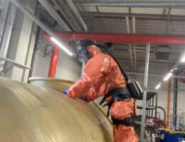 Seilzugangstechniker im chemischen Gefahrstoffanzug während der Tankentleerung  (© NT Service GmbH)