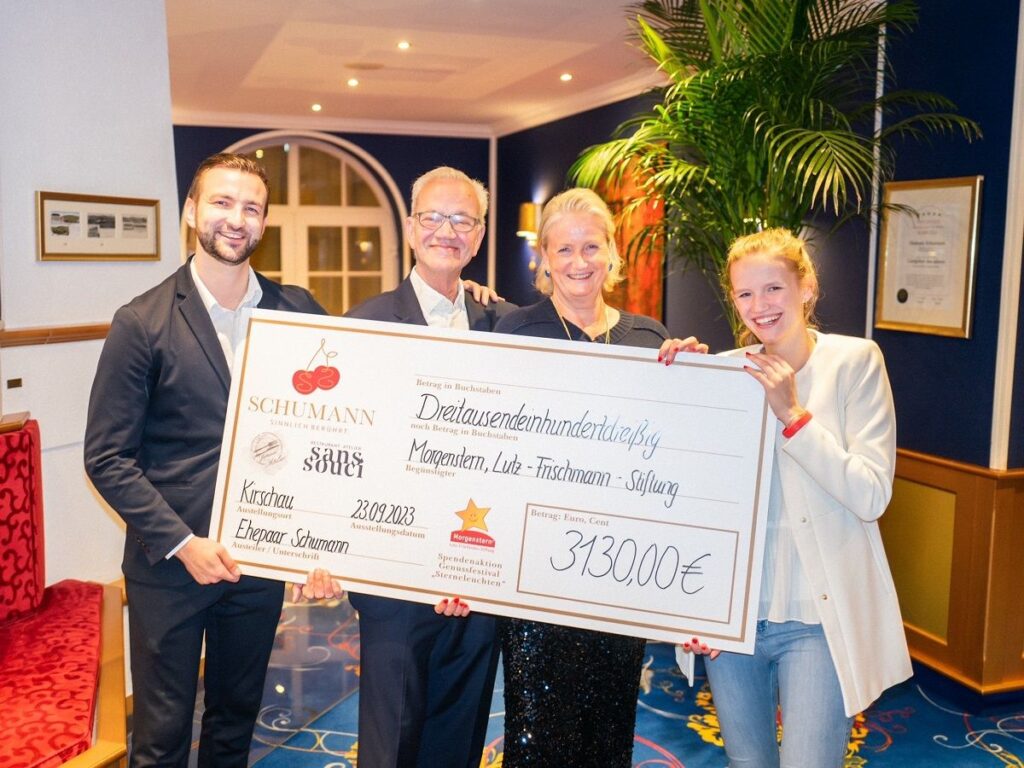 Hotelier Familie Schumann freut sich einen Spendenscheck über 3.130